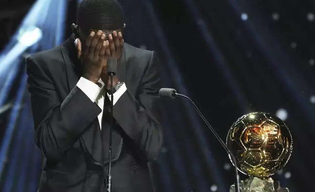 Paris Saint-Germain's Ousmane Dembélé reacts as he receives the 2025 Men's Ballon d'Or during the 69th Ballon d'Or awards ceremony at the Theatre du Chatelet in Paris, Monday, Sept. 22, 2025. (AP Photo/Thibault Camus)