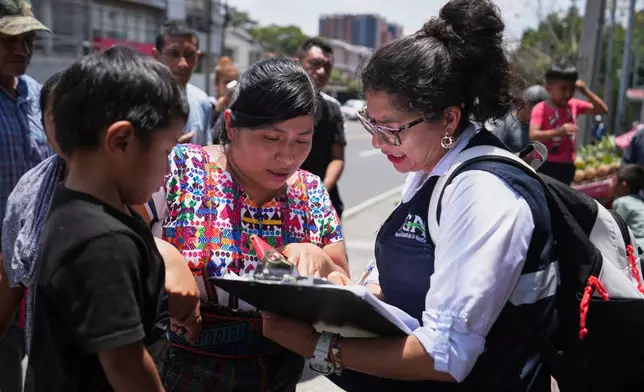 FILE - A relative of an unaccompanied minor deported from the United States reviews the list of those deported outside La Aurora International Airport, in Guatemala City, Aug. 31, 2025. (AP Photo/Moises Castillo, File)