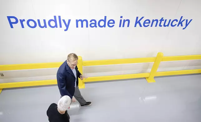 Apple CEO Tim Cook and Corning CEO Wendell Weeks walk during a tour of Corning's iPhone glass manufacturing facility Friday, Sept. 12, 2025, in Harrodsburg, Ky. (AP Photo/Jon Cherry)