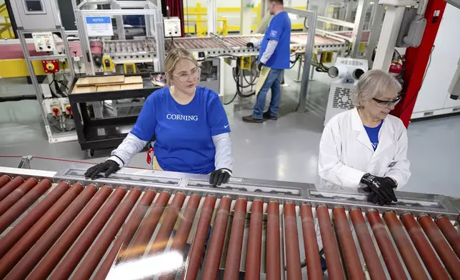 Quality control employees watch as lengths of glass move down the line during a tour of Corning's iPhone glass manufacturing facility Friday, Sept. 12, 2025, in Harrodsburg, Ky. (AP Photo/Jon Cherry)