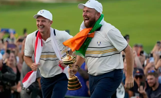 Europe's Shane Lowry and Justin Rose celebrate with the trophy after winning the Ryder Cup golf tournament against the United States on the Bethpage Black golf course, Sunday, Sept. 28, 2025, in Farmingdale, N.Y. (AP Photo/Robert Bukaty)