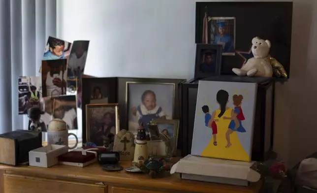 Delphine Cherry's photos of her son, Tyler Randolph, and a painting she made of a mother holding two children sit on a dresser in her home Friday, Sept. 5, 2025, in Hazel Crest, Ill. (AP Photo/Carolyn Kaster)