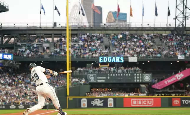 Seattle Mariners' Cal Raleigh hits a solo home run during the first inning of a baseball game against the Colorado Rockies, Wednesday, Sept. 24, 2025, in Seattle. (AP Photo/Ryan Sun)