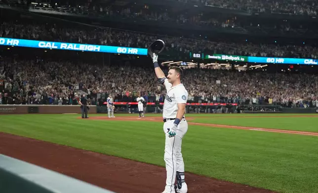 Seattle Mariners' Cal Raleigh waves to the crowd after hitting his 60th home run during the eighth inning of a baseball game against the Colorado Rockies, Wednesday, Sept. 24, 2025, in Seattle. (AP Photo/Ryan Sun)