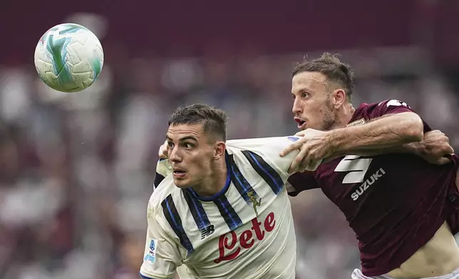 Atalanta's Nikola Krstovic, left, fights for the ball with Torino's Ardian Ismajli during the Italian Serie A soccer match between Torino and Atalanta at the Stadio Olimpico Grande Torino in Torino, Italy, Sunday, Sept. 21, 2025. (Marco Alpozzi/LaPresse via AP)