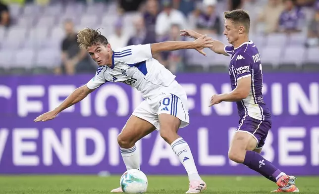 Como's Nicolas Paz, left, fights for the ball with Fiorentina's Hans Nicolussi Caviglia during the Italian Serie A soccer match between Fiorentina and Como at the Artemio Franchi Stadium in Florence, Italy, Sunday, Sept. 21, 2025. (Massimo Paolone/LaPresse via AP)