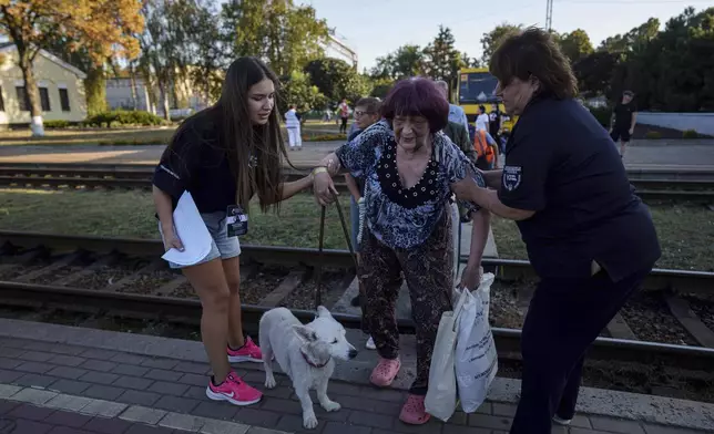 Tetiana Zaichikova, center, walks on a platform during evacuation at the train station in Lozova, Ukraine, Wednesday, Sept. 3, 2025. (AP Photo/Evgeniy Maloletka)