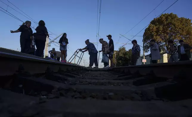 People walk on a platform during evacuation at the train station in Lozova, Ukraine, Wednesday, Sept. 3, 2025. (AP Photo/Evgeniy Maloletka)