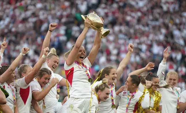 England's Zoe Aldcroft holds a trophy as she celebrates with her teammates after winning the Women's Rugby World Cup final match between England and Canada at the Allianz Stadium, Twickenham, London, Saturday, Sept. 27, 2025. (AP Photo/Alastair Grant)
