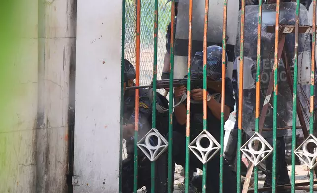 A police officer aims his weapon at protesters outside Parliament building in Kathmandu, Nepal, Monday, Sept. 8, 2025. (AP Photo/Niranjan Shrestha)