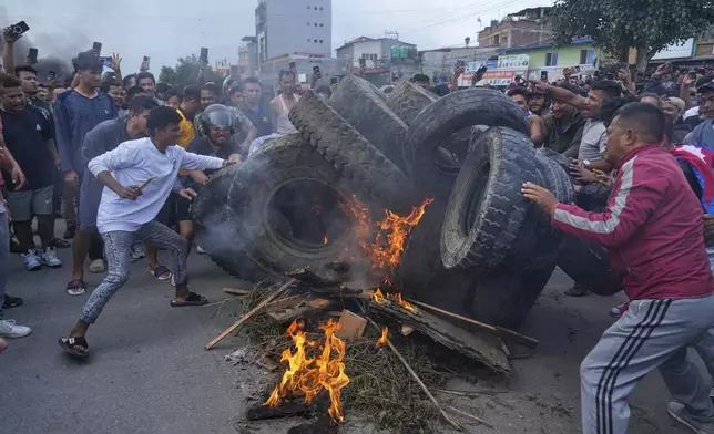Protesters burn tires violating the curfew orders in Kathmandu, Nepal, Tuesday, Sept. 9, 2025. (AP Photo/Niranjan Shrestha)