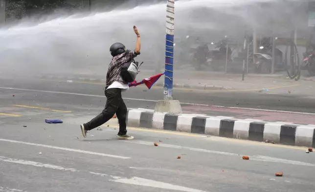 A protestor clashes with the riot police outside the Parliament building in Kathmandu, Nepal, Monday, Sept. 8, 2025. (AP Photo/Niranjan Shrestha)