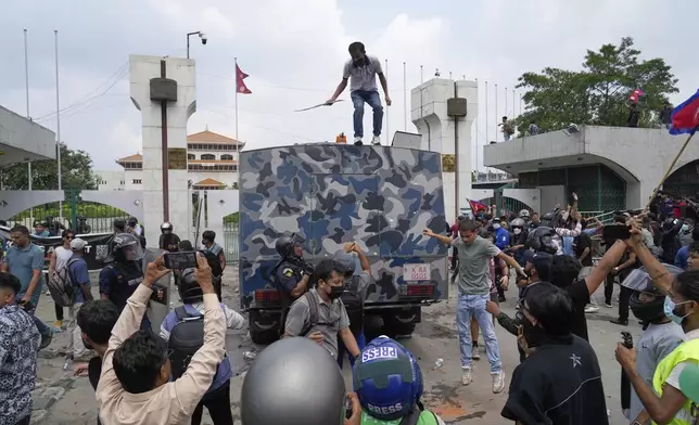Protesters surround an armored vehicle of a police during clashes outside the Parliament building in Kathmandu, Nepal, Monday, Sept. 8, 2025. (AP Photo/Niranjan Shrestha)