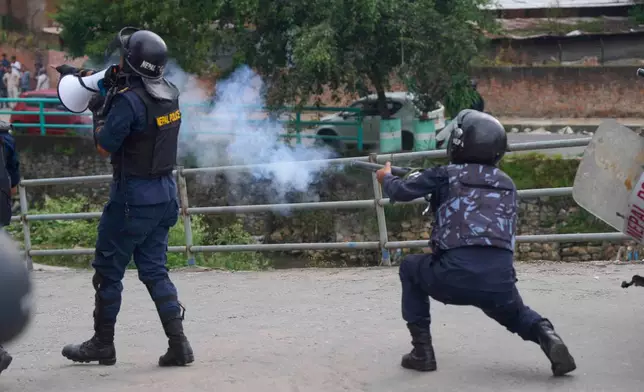 A policemen fires a tear gas shell towards protesters during clashes outside the parliament building in Kathmandu, Nepal, Monday, Sept. 8, 2025. (AP Photo/Niranjan Shrestha)