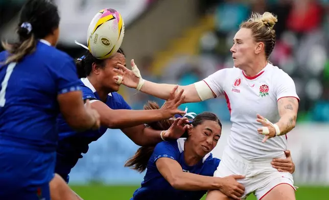 FILE - England's Megan Jones, right, is tackled by Samoa's Keilamarita Pouri-Lane, center, during the Women's Rugby World Cup 2025 Pool A match at Franklin's Gardens, Saturday August 30, 2025, in Northampton, England. (Ben Whitley/PA via AP)
