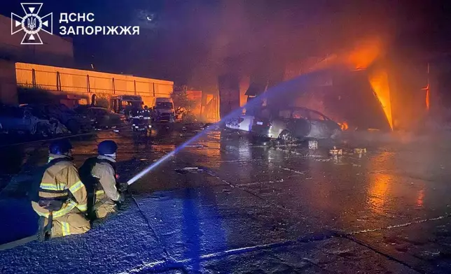 In this photo provided by the Ukrainian Emergency Services on Tuesday, Sept. 16, 2025, rescue workers put out a fire of a building destroyed by a Russian strike in Zaporizhzhia, Ukraine. (Ukrainian Emergency Service via AP)