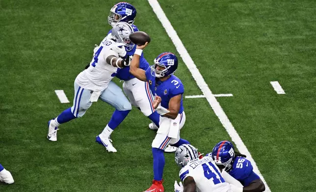New York Giants quarterback Russell Wilson (3) throws a pass under pressure from Dallas Cowboys defensive end Sam Williams (54) in the first half of an NFL football game Sunday, Sept. 14, 2025, in Arlington, Texas. (AP Photo/Jerome Miron)