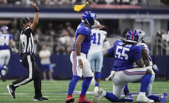 An official throws a penalty flag after a play that involved New York Giants' James Hudson III (55) in the first half of an NFL football game against the Dallas Cowboys Sunday, Sept. 14, 2025, in Arlington, Texas. (AP Photo/Jeffrey McWhorter)