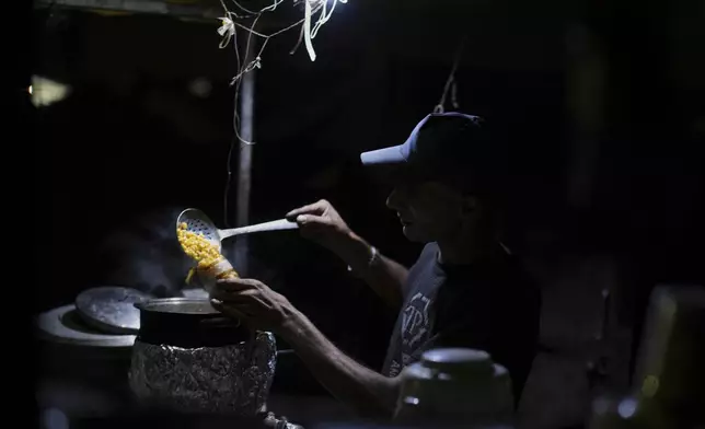 A Palestinian street vendor prepares corn for sale near the beachfront at a tent camp for displaced people in the Gaza City port, Tuesday, Sept. 2, 2025. (AP Photo/Jehad Alshrafi)