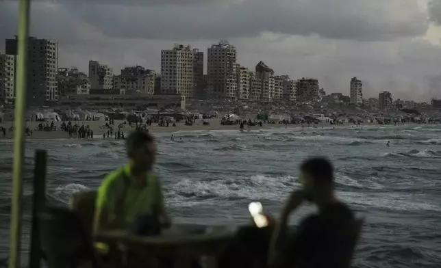 Palestinians spend time at the seafront next to a tent camp in the Gaza City port, Tuesday, Sept. 2, 2025. (AP Photo/Jehad Alshrafi)