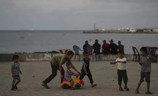 Palestinian children play at the seafront next to a tent camp in the Gaza City port, Tuesday, Sept. 2, 2025. (AP Photo/Jehad Alshrafi)