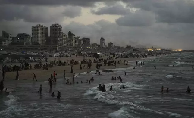 Displaced Palestinians cool off in the Mediterranean Sea near the port of Gaza City, Tuesday, Sept. 2, 2025. (AP Photo/Jehad Alshrafi)