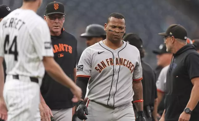 San Francisco Giants manager Bob Melvin, center left, walks Rafael Devers away from a scuffle that started after Dever's two-run home run off Colorado Rockies starting pitcher Kyle Freeland in the first inning of a baseball game Tuesday, Sept. 2, 2025, in Denver. (AP Photo/David Zalubowski)