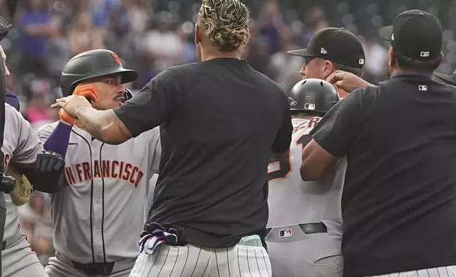 San Francisco Giants' Willy Adames, back left, squares off with Colorado Rockies starting pitcher Kyle Freeland, back right, after Freeland exchanged words with the Giants' Rafael Devers following Devers' two-run home run in the first inning of a baseball game Tuesday, Sept. 2, 2025, in Denver. (AP Photo/David Zalubowski)