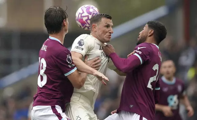 Nottingham Forest's Chris Wood (centre) battles with Burnley's Hjalmar Ekdal (left) and Josh Laurent during the English Premier League soccer match between Burnley and Nottingham Forest , at Turf Moor, Burnley, England, Saturday Sept. 20, 2025. (Ian Hodgson /PA via AP)