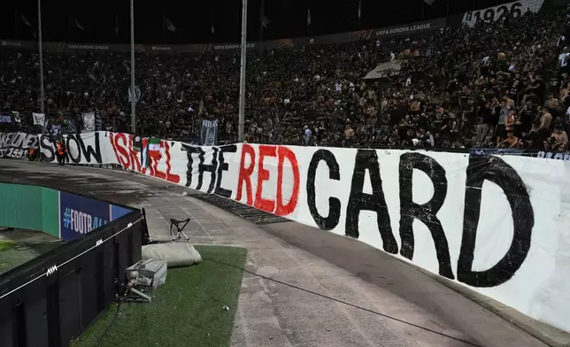 Park fans display a huge banner that reads "show Israel the red card during the Europa League soccer match between PAOK and Maccabi Tel Aviv at Toumpa stadium, in Thessaloniki, Greece, Wednesday, Sept. 24, 2025. (AP Photo/Giannis Papanikos)