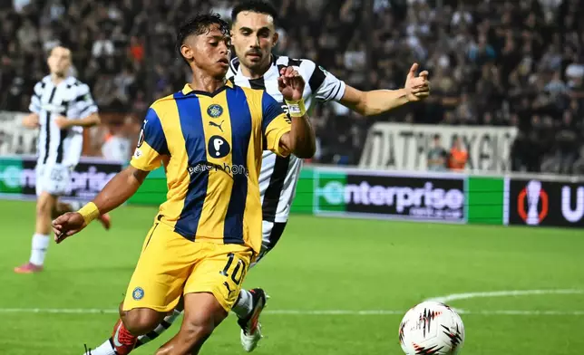 Maccabi Tel Aviv's Kervin Andrade runs for the ball ahead of PAOK's Giannis Michailidis during the Europa League soccer match between PAOK and Maccabi Tel Aviv at Toumpa stadium, in Thessaloniki, Greece, Wednesday, Sept. 24, 2025. (AP Photo/Giannis Papanikos)