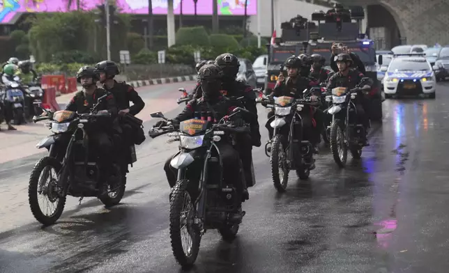 Officers of Indonesian National Police's paramilitary unit Mobile Brigade, patrol a street following days of violent protests against lavish allowances given to parliament members, at the main business district in Jakarta, Indonesia, Sunday, Aug. 31, 2025. (AP Photo/Dita Alangkara)