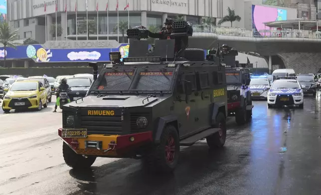 Officers of Indonesian National Police's paramilitary unit Mobile Brigade, man their position on armored vehicles as they patrol a street following days of violent protests against lavish allowances given to parliament members, at the main business district in Jakarta, Indonesia, Sunday, Aug. 31, 2025. (AP Photo/Dita Alangkara)