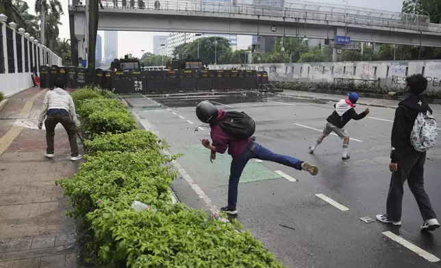 Protesters throw rocks at the police during a protest against lavish allowances given to parliament members, outside the parliament in Jakarta, Indonesia, Sunday, Aug. 31, 2025. (AP Photo/Dita Alangkara)