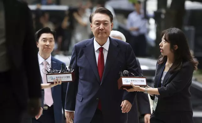 FILE - Former South Korean President Yoon Suk Yeol, center, arrives at a court to attend a hearing to review his arrest warrant requested by special prosecutors in Seoul, South Korea, July 9, 2025. (Kim Hong-Ji/Pool Photo via AP, File)