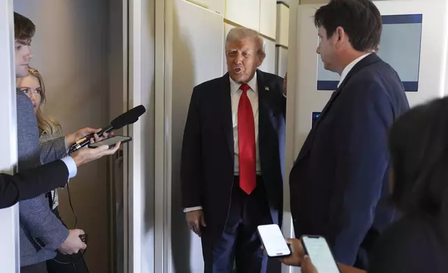 President Donald Trump speaks with journalists on Air Force One en route to Stansted Airport near London, Tuesday, Sept. 16, 2025. (AP Photo/Evan Vucci)