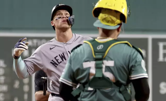 New York Yankees designated hitter Aaron Judge, left, celebrates as he runs to home plate after hitting a home run during the first inning of a baseball game against the Boston Red Sox, Friday, Sept. 12, 2025, in Boston. (AP Photo/Mark Stockwell)