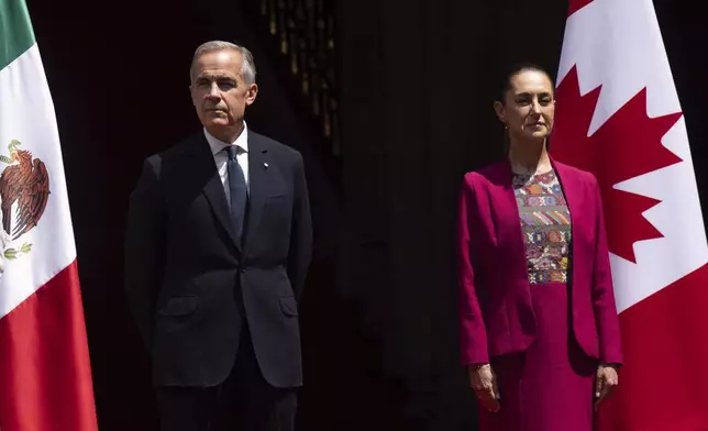 Canada's Prime Minister Mark Carney and Mexican President Claudia Sheinbaum stand on the podium during an official welcome ceremony at the National Palace in Mexico City, Thursday, Sept. 18, 2025. (Adrian Wyld/The Canadian Press via AP)