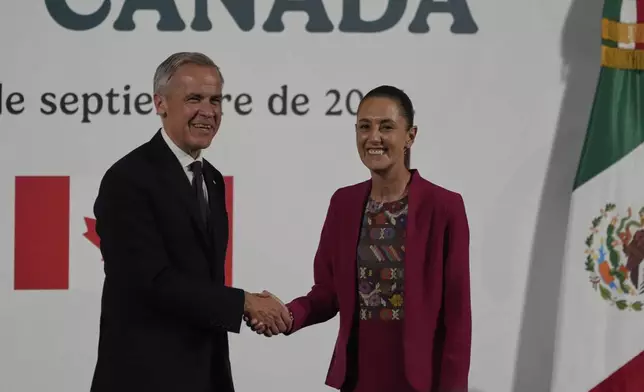 Canada's Prime Minister Mark Carney, left, and Mexico's President Claudia Sheinbaum shake hands after a joint press conference at the National Palace in Mexico City, Thursday, Sept. 18, 2025. (AP Photo/Fernando Llano)