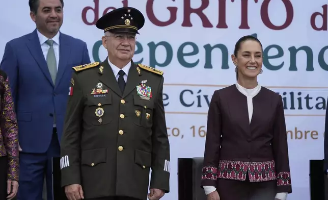 Defense Minister Gen. Ricardo Trevilla Trejo, left, and President Claudia Sheinbaum look out at troops before the start of the annual Independence Day parade in the capital's main square, the Zocalo, in Mexico City, Tuesday, Sept. 16, 2025. (AP Photo/Fernando Llano)