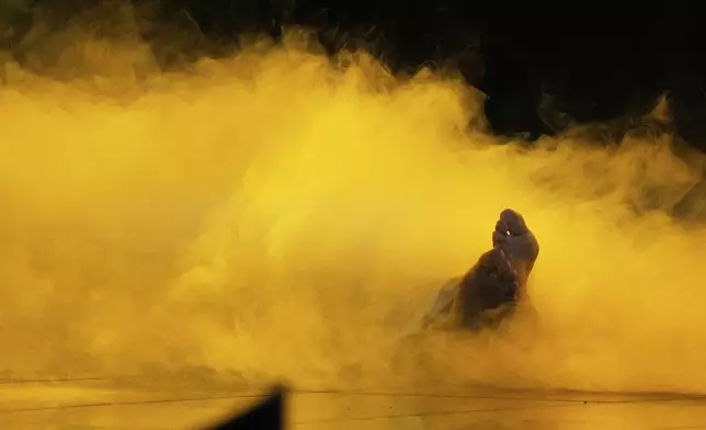 Kazakhstan's Yernar Sadirbayev (Amre) lies in a cloud of smoke as he performs the song "Steppe Light" at the International Music Competition "Intervision" at the Live Arena outside Moscow, Russia, Saturday, Sept. 20, 2025. (AP Photo/Alexander Zemlianichenko)
