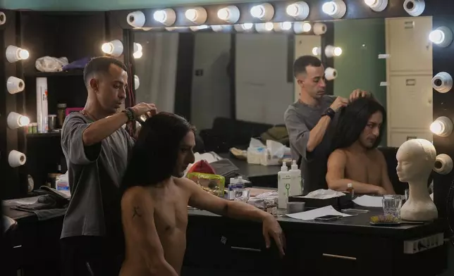 Alexandre Paulikevitch gets his wig adjusted by an assistant backstage before performing at a theatre in Beirut, Lebanon, Thursday, Sept. 11, 2025. (AP Photo/Hussein Malla)