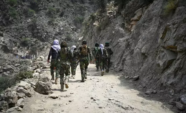 Taliban soldiers walk through a dirt road as they try to reach the quake-hit region to assist survivors after Sunday night's powerful 6.0-magnitude earthquake that struck several provinces, in the Nurgol district, Kunar province, eastern Afghanistan, Tuesday, Sept. 2, 2025. (AP Photo/Nava Jamshidi)
