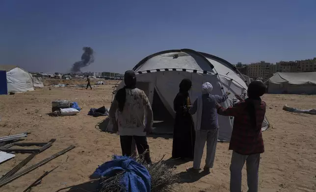 The Abu Jarad family stands in front of their tent in Khan Younis, Gaza Strip, following their displacement from Gaza City, Sept. 11, 2025. (AP Photo/Abdel Kareem Hana)