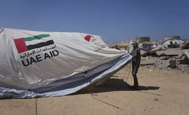 Ne'man Abu Jarad, 50, sets up his family's tent in Khan Younis, Gaza Strip, following their displacement from Gaza City, Sept. 11, 2025. (AP Photo/Abdel Kareem Hana)
