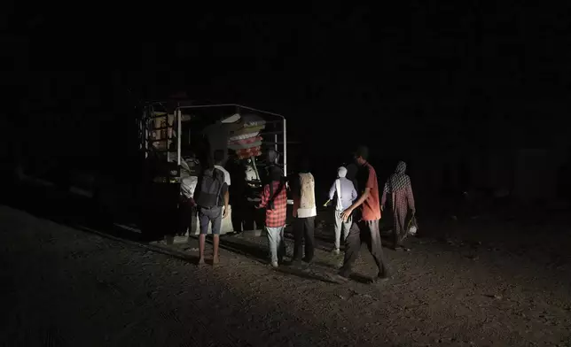 Members of the Abu Jarad family unload their belongings from a truck in Khan Younis, Gaza Strip, Sept. 10, 2025, after fleeing Gaza City following evacuation orders issued by the Israeli army. (AP Photo/Abdel Kareem Hana)