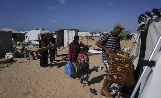 The Abu Jarad family moves their belongings into a newly built tent in Khan Younis, Gaza Strip, after being displaced from Gaza City, Sept. 11, 2025. (AP Photo/Abdel Kareem Hana)