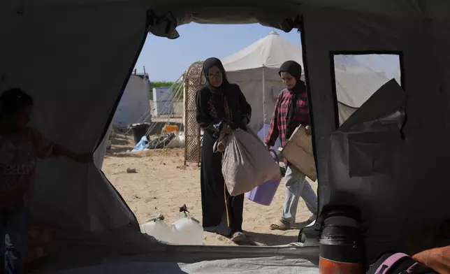 The Abu Jarad family moves their belongings into a newly built tent in Khan Younis, Gaza Strip, after being displaced from Gaza City, Sept. 11, 2025. (AP Photo/Abdel Kareem Hana)