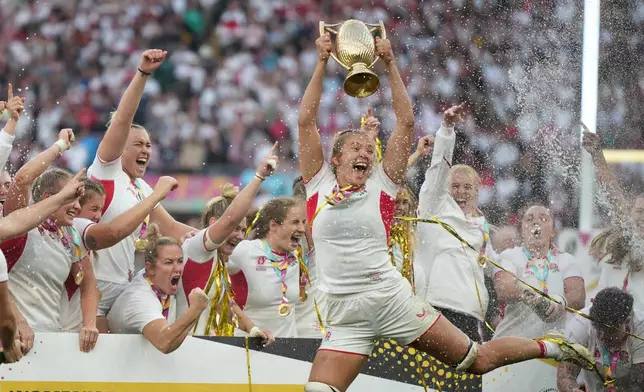 England's Zoe Aldcroft holds a trophy as she celebrates with her teammates after winning the Women's Rugby World Cup final match between England and Canada at the Allianz Stadium, Twickenham, London, Saturday, Sept. 27, 2025. (AP Photo/Alastair Grant)