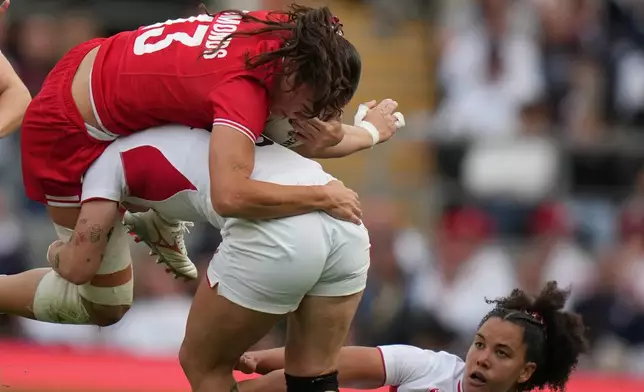 Canada's Florence Symonds, left, is stopped by England's Zoe Harrison during the Women's Rugby World Cup final match between England and Canada at the Allianz Stadium, Twickenham, London, Saturday, Sept. 27, 2025. (AP Photo/Alastair Grant)